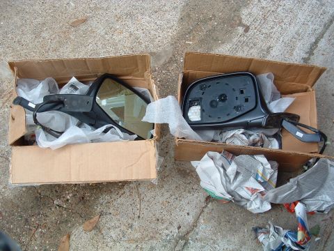 1993 Ford Bronco - A pair of side mirrors, one showing the glass and the other the backing, are presented in cardboard boxes.