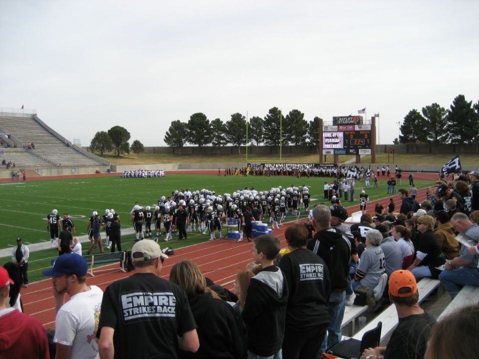 Football stadium with teams on field and spectators in bleachers