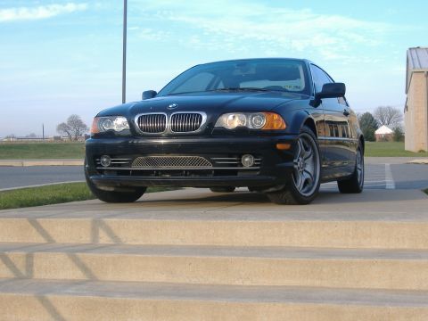 2001 BMW 3 Series - A black 2001 BMW 3 Series sedan is parked on concrete steps under a blue sky.