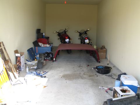 1995 Ford Bronco - Garage scene with two motorcycles and a detached car roof, along with various tools and storage items.