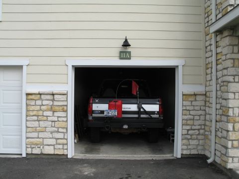 1995 Ford Bronco - A Ford pickup truck is parked inside a garage, equipped with extra fuel cans and a flag.