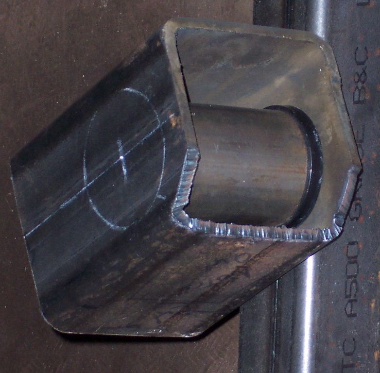 Close-up of a metal tube with a smaller tube inserted, showing cut edges and chalk marks