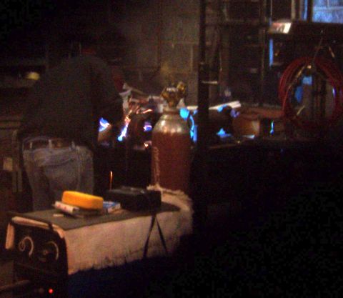 1978 Ford Bronco - A person is welding in a dimly lit workshop, with various tools and equipment visible.