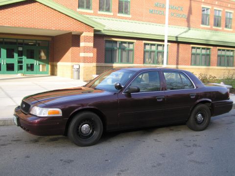 1991 Ford LTD Crown Victoria - Dark sedan parked on asphalt in front of Merrimack Middle School building.