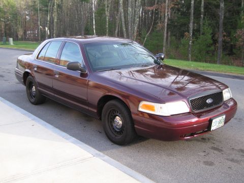 1991 Ford LTD Crown Victoria - Maroon sedan parked on a street, showing its front quarter and side profile. The license plate is visible.