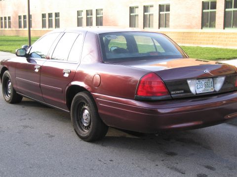 1991 Ford LTD Crown Victoria - This maroon sedan, likely from the early 2000s, is viewed from the rear, showing its license plate.