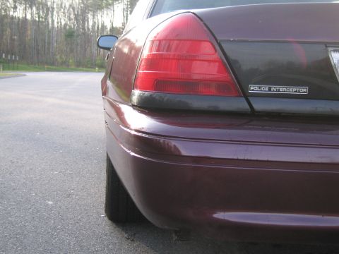 1991 Ford LTD Crown Victoria - Rear view of a police car, showing the taillight and 'POLICE INTERCEPTOR' badging.