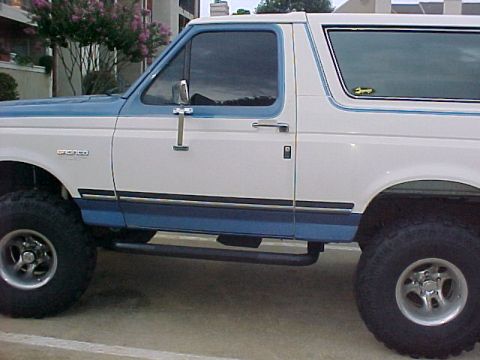 1990 Ford Bronco - Side view of a 1990 Ford Bronco with two-tone paint and custom accessories.