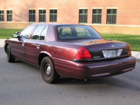 1991 Ford LTD Crown Victoria - This maroon sedan, likely a Ford Crown Victoria from the early 2000s, is seen from the rear with a license plate reading 233-6824.