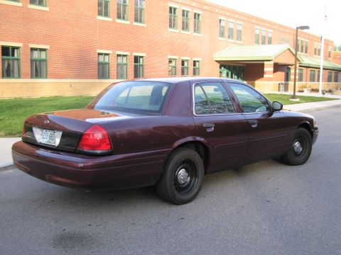 1991 Ford LTD Crown Victoria - This maroon Ford Crown Victoria sedan is seen from a rear three-quarter angle in front of a brick building.