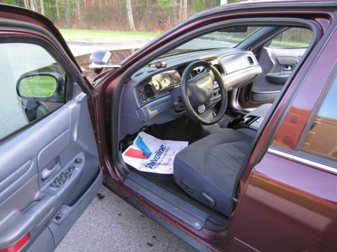 1991 Ford LTD Crown Victoria - Interior view of a maroon 1991 Ford Crown Victoria LTD, showing the dashboard, steering wheel, and front seats.