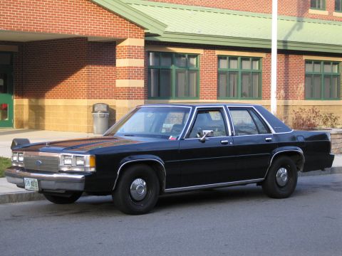 1991 Ford LTD Crown Victoria - This black sedan's body style suggests a model year in the 1980s, not 1991.