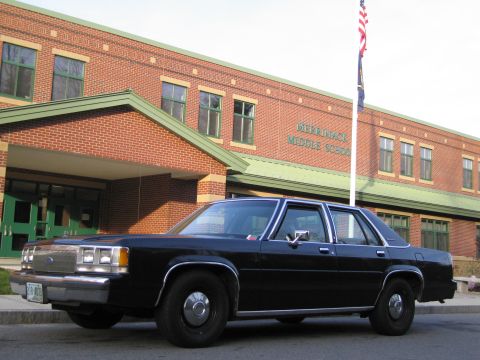 1991 Ford LTD Crown Victoria - A black sedan is parked in front of Merrimack Middle School.