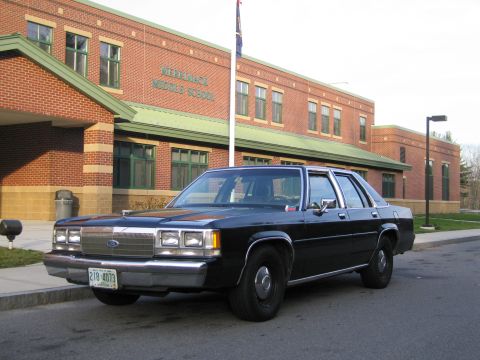 1991 Ford LTD Crown Victoria - Black 1991 Ford Crown Victoria LTD parked on asphalt in front of a brick school building.
