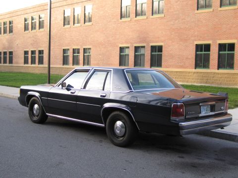 1991 Ford LTD Crown Victoria - This 1991 Ford Crown Victoria LTD is seen from the rear, parked curbside in front of a brick building.