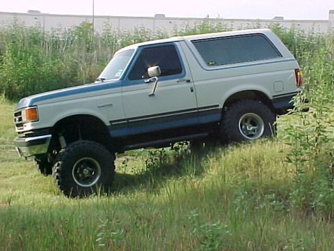 1990 Ford Bronco - This 1990 Ford Bronco is shown driving off-road on a grassy hill.