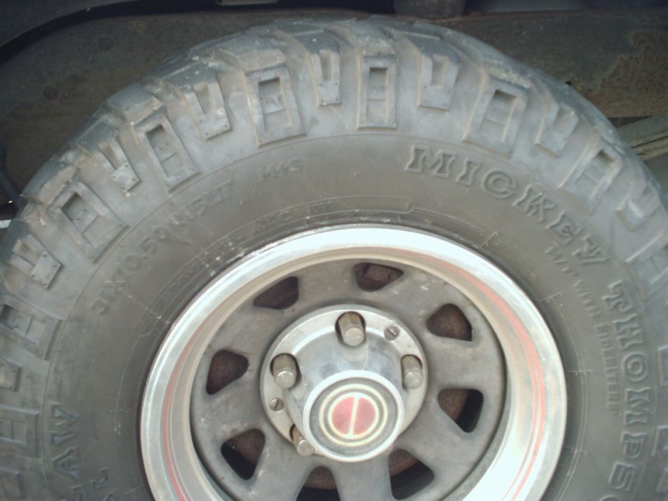 Close-up of a Mickey Thompson tire on a wheel with a red and silver center cap