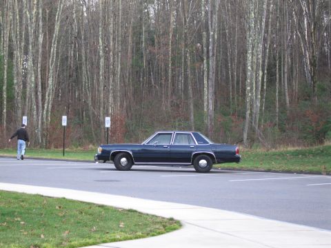 1991 Ford LTD Crown Victoria - A 1991 Ford Crown Victoria LTD is seen parked in a lot with a person walking away from it in the background.