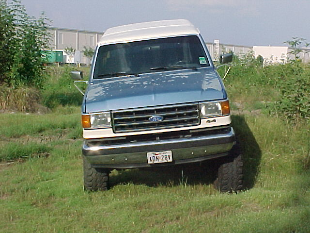 Ford Econoline van, blue and white, parked on grass