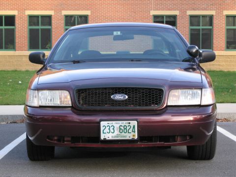1991 Ford LTD Crown Victoria - This dark red Ford Crown Victoria is seen from the front, a black grille and a New Hampshire license plate.