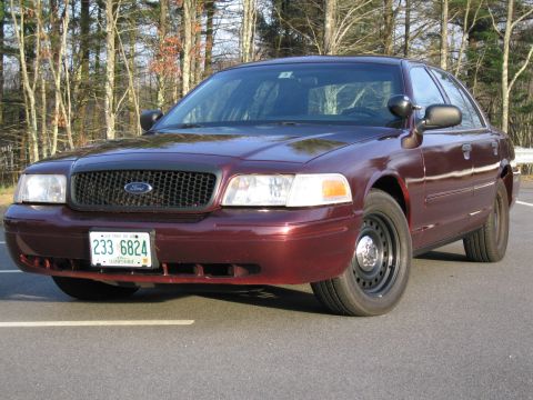 1991 Ford LTD Crown Victoria - This maroon sedan features a black grille and steel wheels, with a license plate visible on the front.