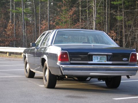1991 Ford LTD Crown Victoria - Rear view of a 1991 Ford Crown Victoria LTD, a dark blue sedan parked in a lot.