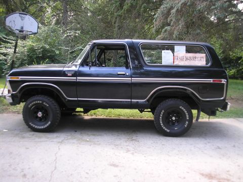 1978 Ford Bronco - Side view of a black 1978 Ford Bronco with a "FOR SALE" sign visible in the rear window.