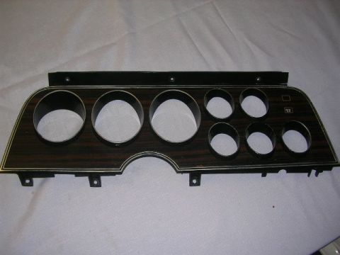 1975 Ford Ranchero - This is a dashboard instrument cluster bezel with a woodgrain finish and openings for gauges.