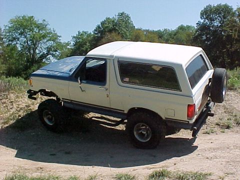 1990 Ford Bronco - This lifted Ford Bronco is shown from a three-quarter front angle on a sunny day.