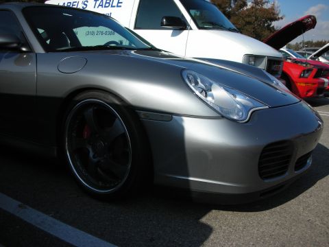 1998 Ford Crown Victoria - front quarter of a silver Porsche 911 (996) with a chrome-lipped wheel and red brake caliper at a meet.