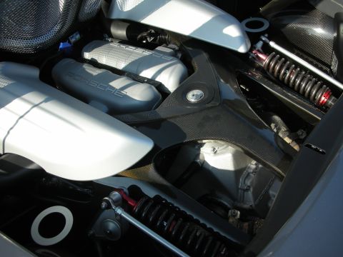 1998 Ford Crown Victoria - mid-mounted Porsche engine with a PORSCHE-stamped cover and red-spring coilover suspension visible.