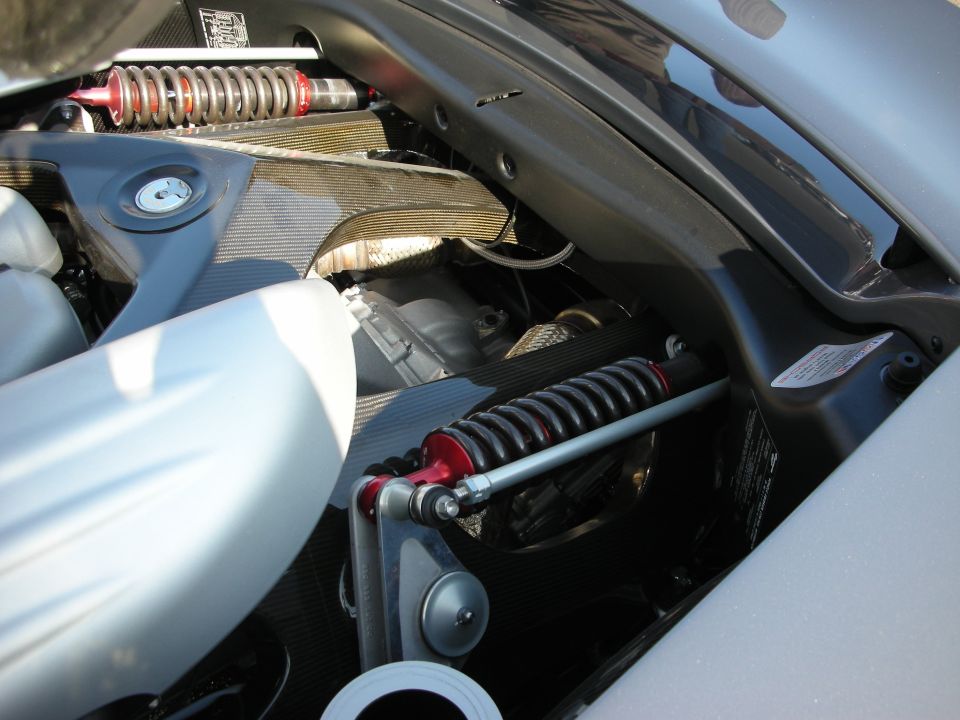 Engine bay suspension detail with red-spring coilover shocks on silver car