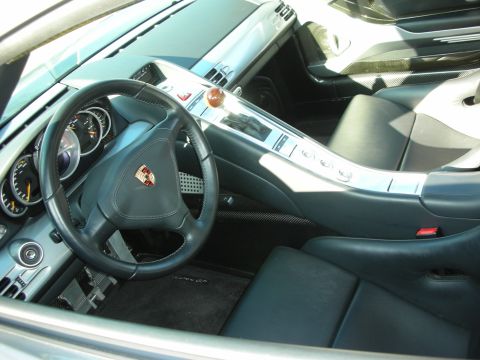 1998 Ford Crown Victoria - interior of a Porsche showing a crest-badged steering wheel, brushed-silver console and black leather seats.