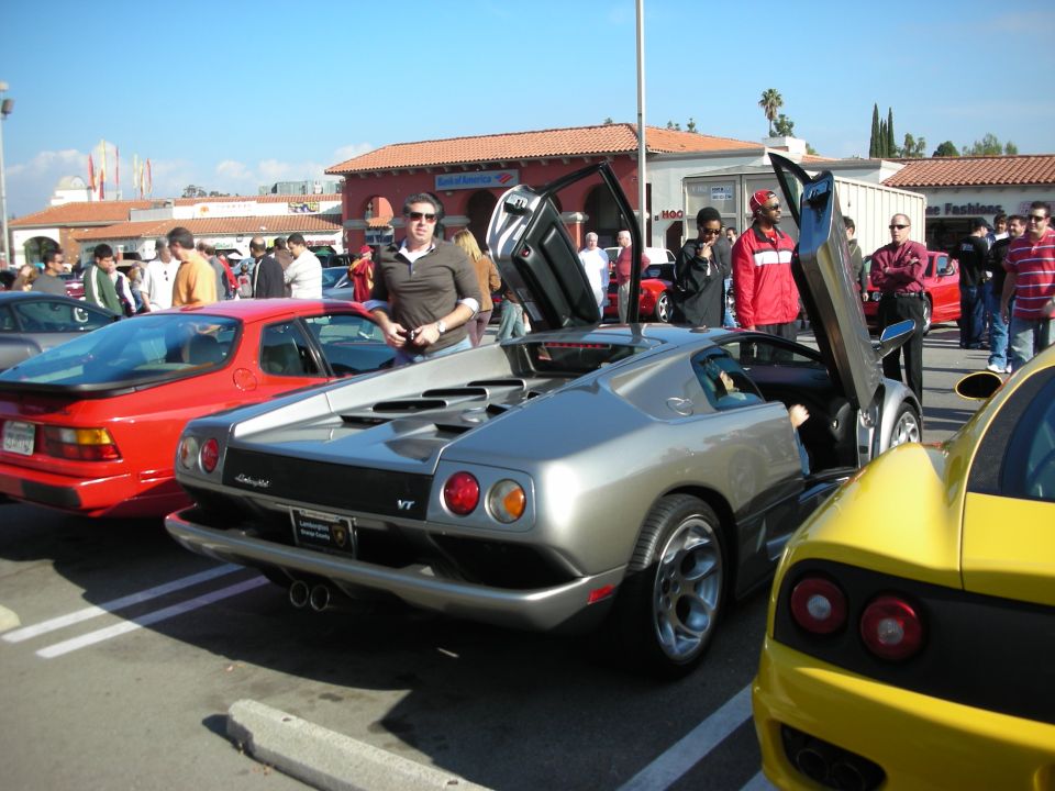 Silver Lamborghini Diablo with scissor doors open at an outdoor car show