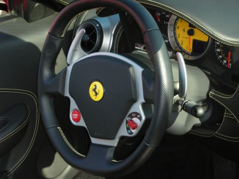 1998 Ford Crown Victoria - Ferrari F430 steering wheel features a red engine-start button and manettino, with a yellow-faced tachometer behind it.