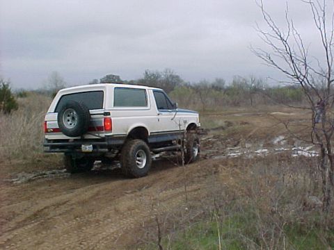 1990 Ford Bronco - This 1992 Ford Bronco is shown from the rear, driving off-road.
