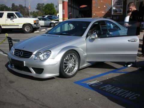 1998 Ford Crown Victoria - Front three-quarter of a silver Mercedes-Benz CLK DTM AMG coupe with flared wide-body fenders, mesh wheels, and a tall rear wing.