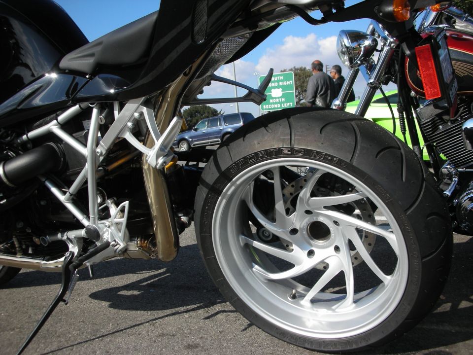 Rear wheel and tubular swingarm detail of a black BMW motorcycle