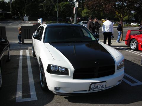 1998 Ford Crown Victoria - Front view of a white Dodge Charger fitted with a matte-black hood, parked at an outdoor car meet.