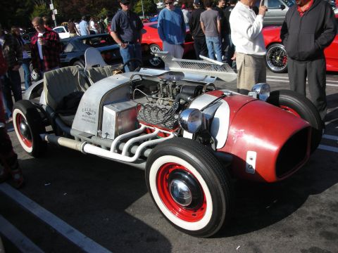 1998 Ford Crown Victoria - custom hot-rod roadster with a red hose-style nose, exposed chrome-headers V8 and whitewall tires displayed at a car meet.