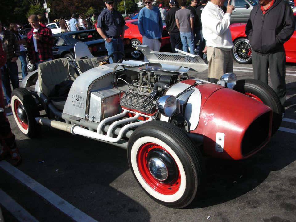 Hot rod roadster with red nose, exposed V8 engine and whitewall tires