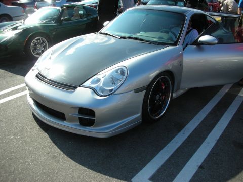 1998 Ford Crown Victoria - Front quarter view of a silver Porsche 911 with black multi-spoke wheels and a lowered stance at a car meet.