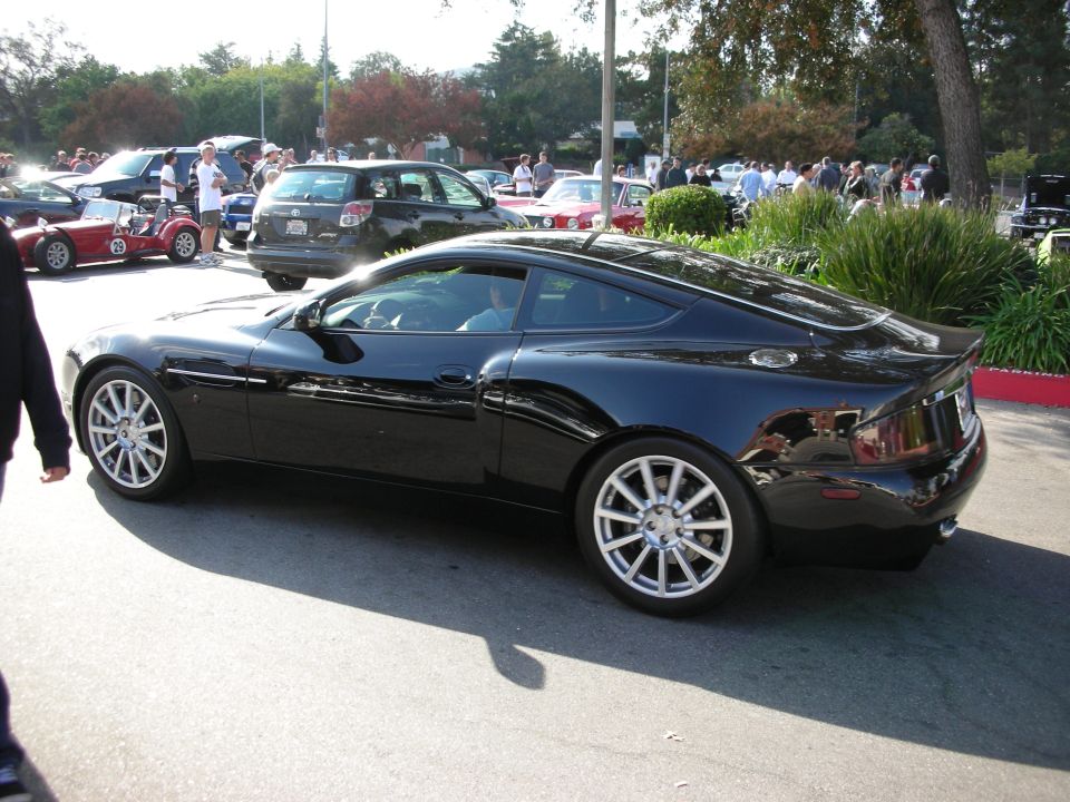 Black Aston Martin Vanquish coupe in profile with multi-spoke wheels