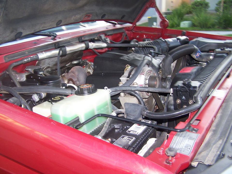 1997 Ford F-250 engine bay with V8 engine, alternator, and coolant reservoir