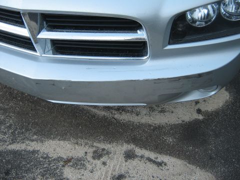 2006 Dodge Charger - Front view of a silver 2006 Dodge Charger showing the grille and bumper with some wear and tear.