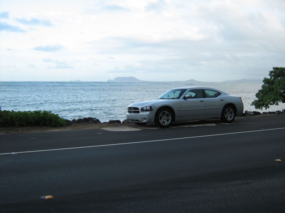 Silver 2006 Dodge Charger parked on a road next to the ocean