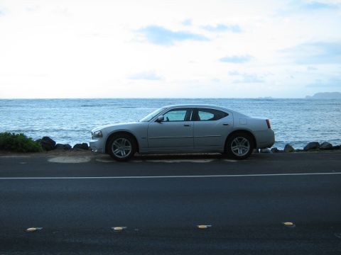 2006 Dodge Charger - A silver sedan is parked on the side of a road with the ocean in the background.