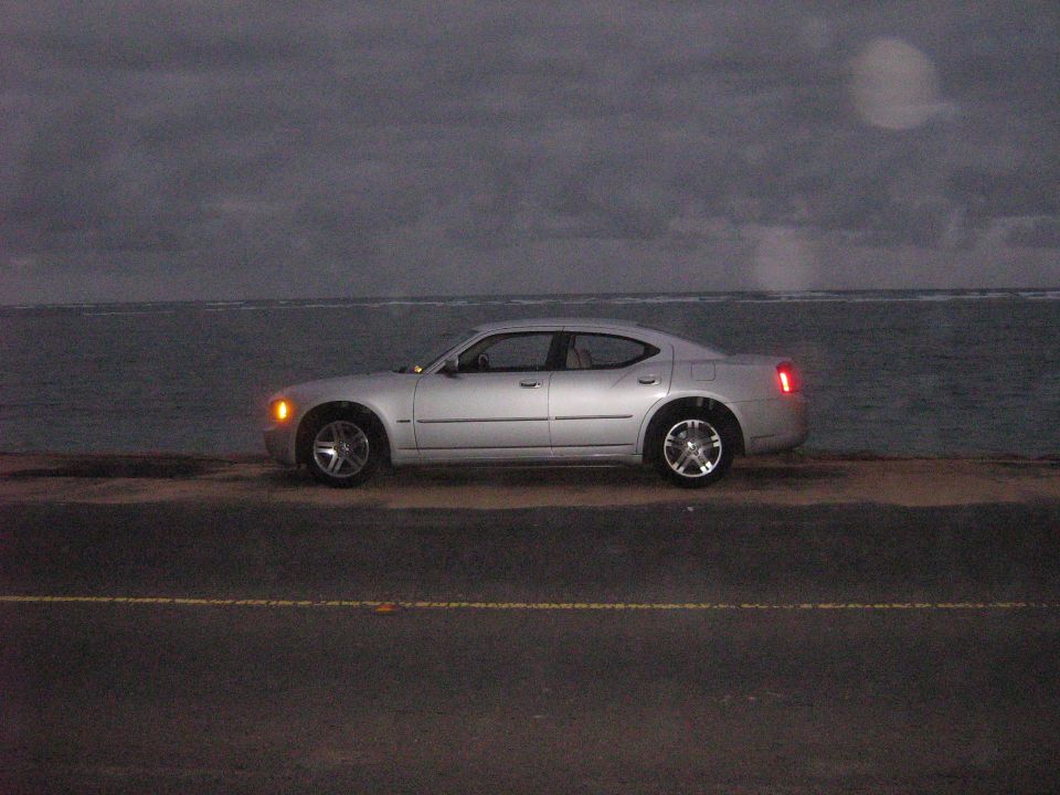 Silver 2006 Dodge Charger parked on a road next to the ocean