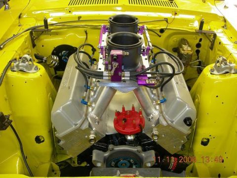 1972 Ford Ranchero - Close-up of a modified V8 engine in a yellow engine bay, dual carburetors and custom components.