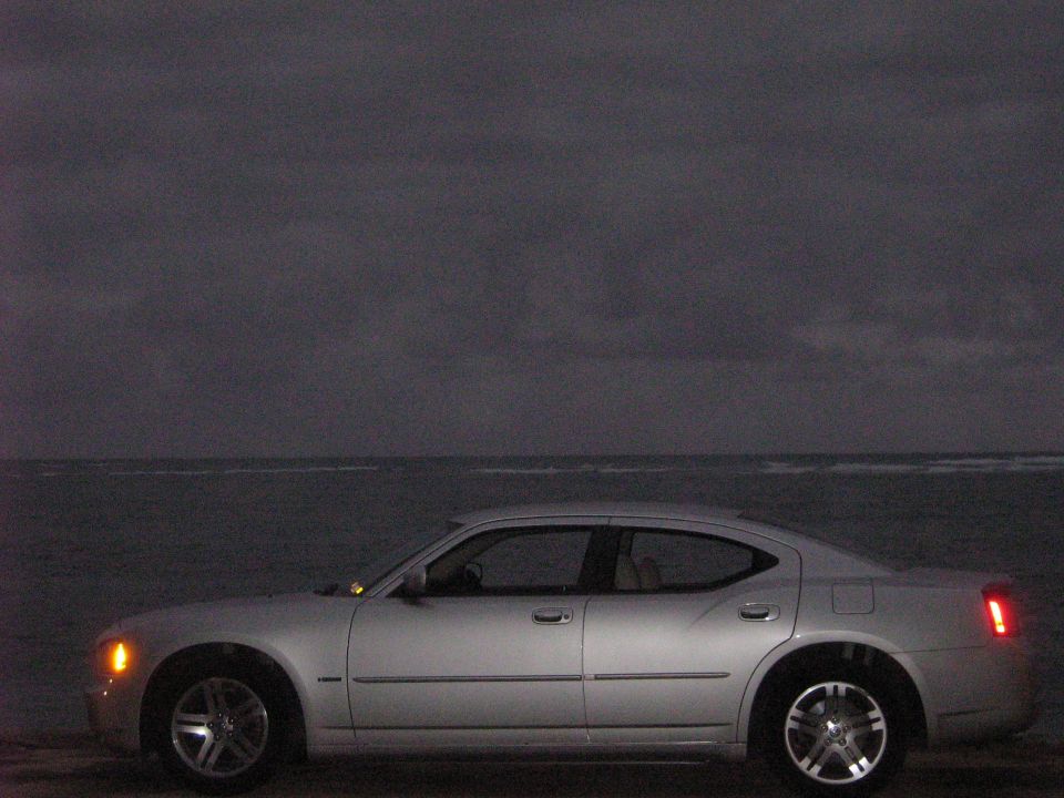 Silver 2006 Dodge Charger side view parked by the ocean